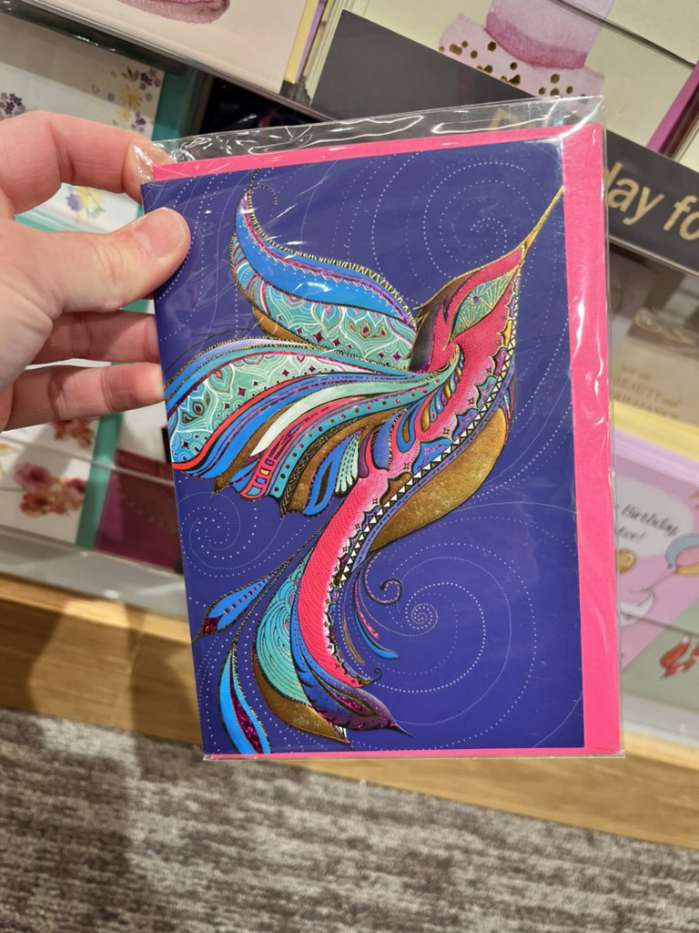 One of Michele's licensed greeting card designs held in a retail store